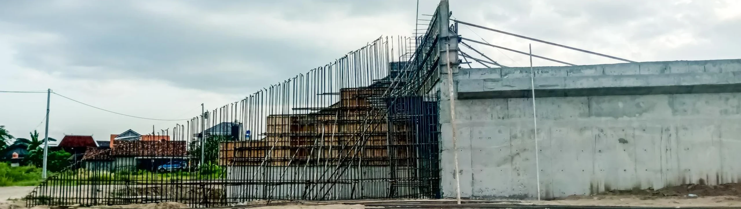 Reinforced concrete commercial wall with exposed steel rebar and formwork at a construction site in Fort Mill, SC.