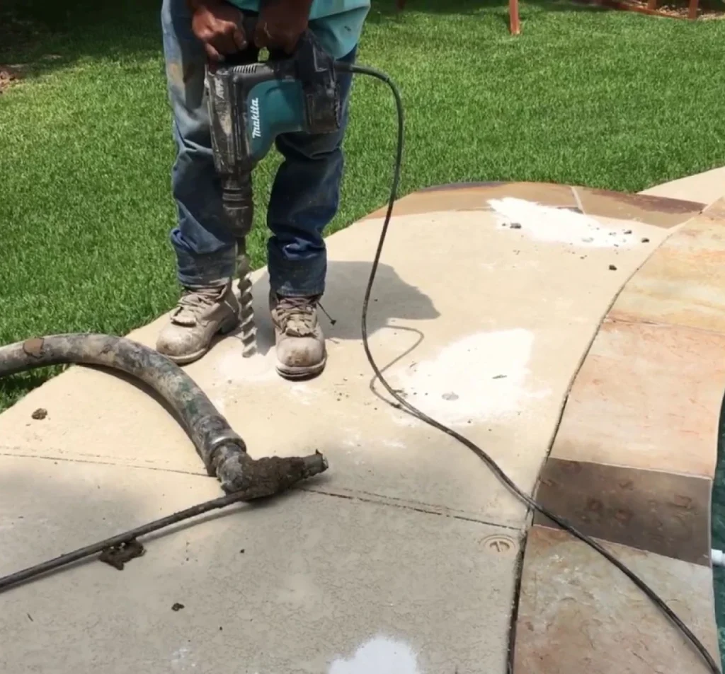 Technician drilling injection holes for concrete patio lifting in Fort Mill, SC