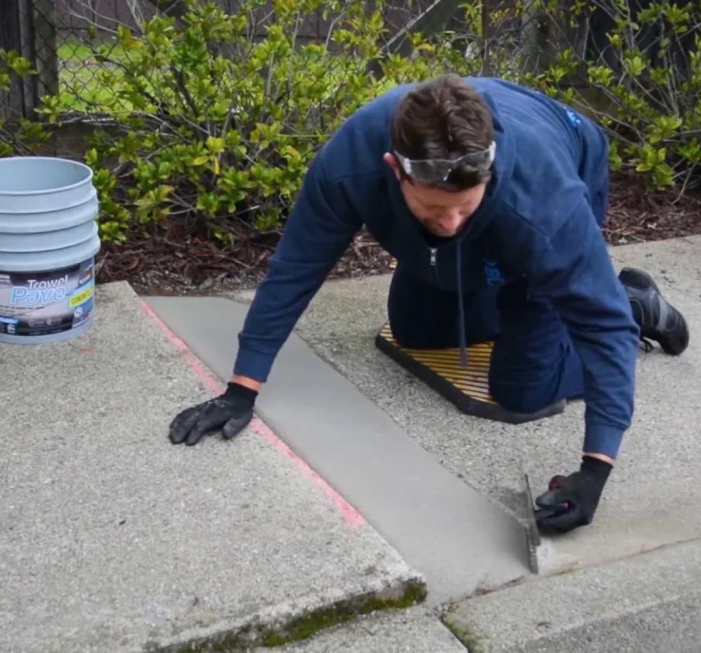 Technician smoothing a repaired concrete sidewalk joint in Fort Mill, SC
