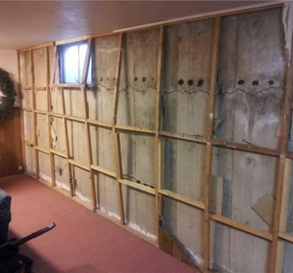 Cracked and bowing basement wall exposed before repair in Fort Mill, SC