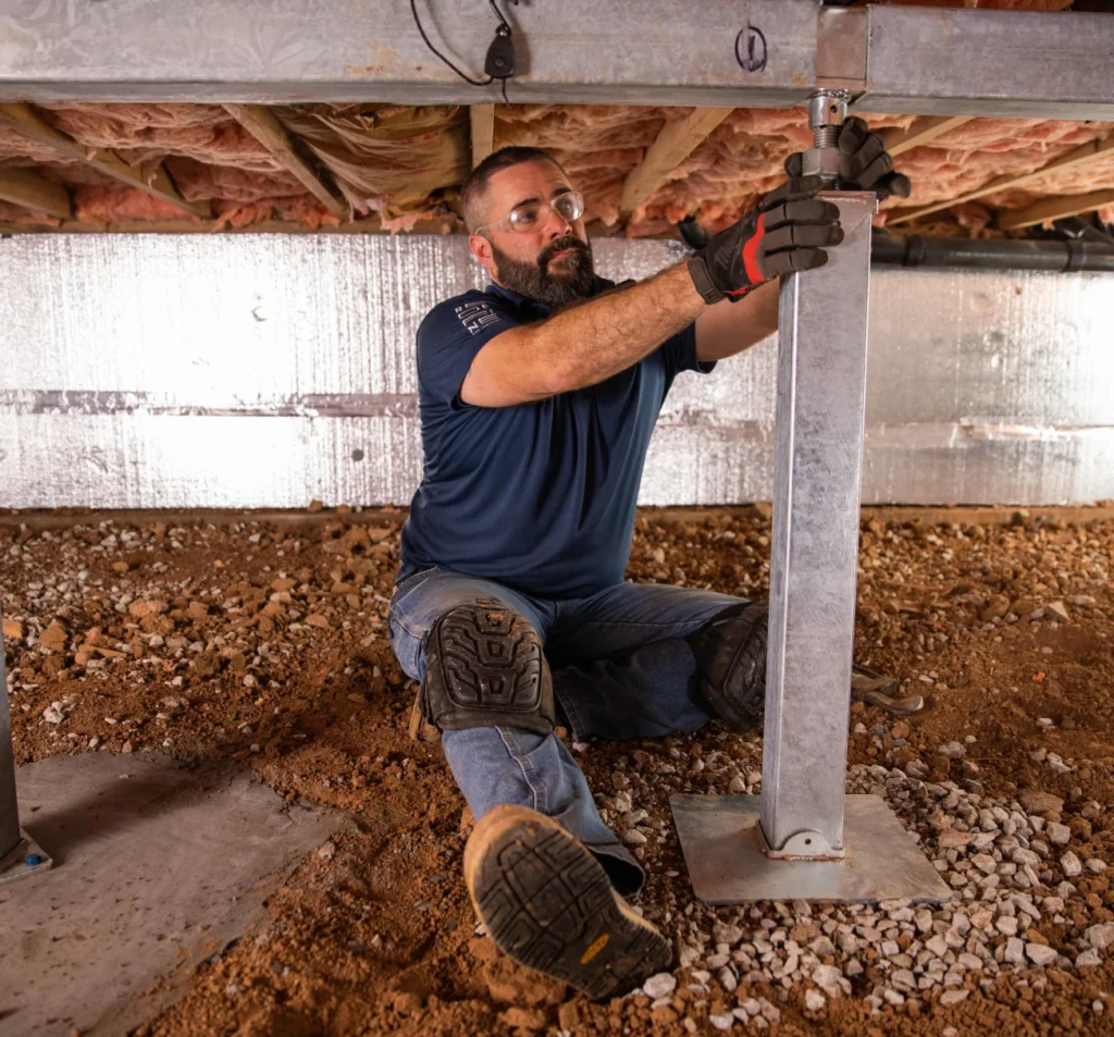 Technician adjusting a crawl space support jack in Fort Mill, NC
