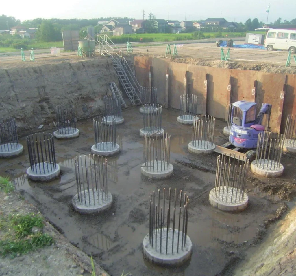 Deep foundation construction site with reinforced concrete pile caps, steel rebar cages, and excavation equipment in Fort Mill, SC.
