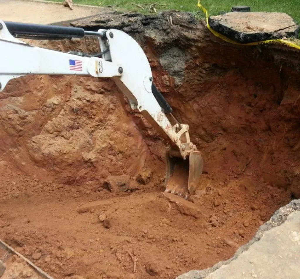 Excavator preparing unstable soil for polyurethane foam injection in Fort Mill, SC