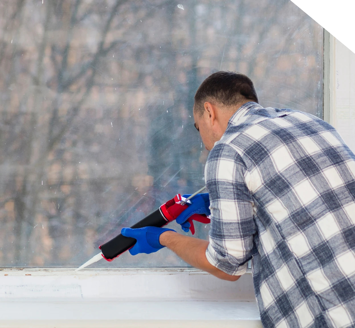 Technician applying polyurethane sealant around a window in Fort Mill, SC