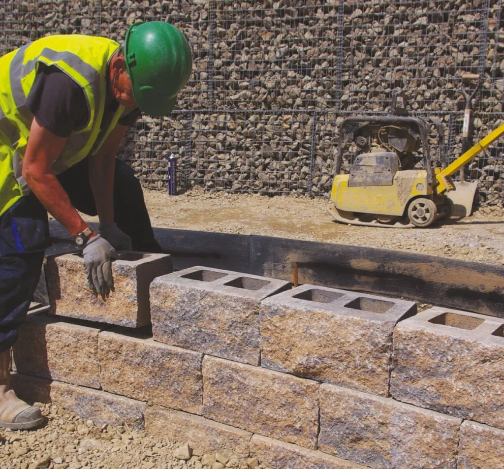 Worker installing concrete blocks during retaining wall repair in Fort Mill, SC